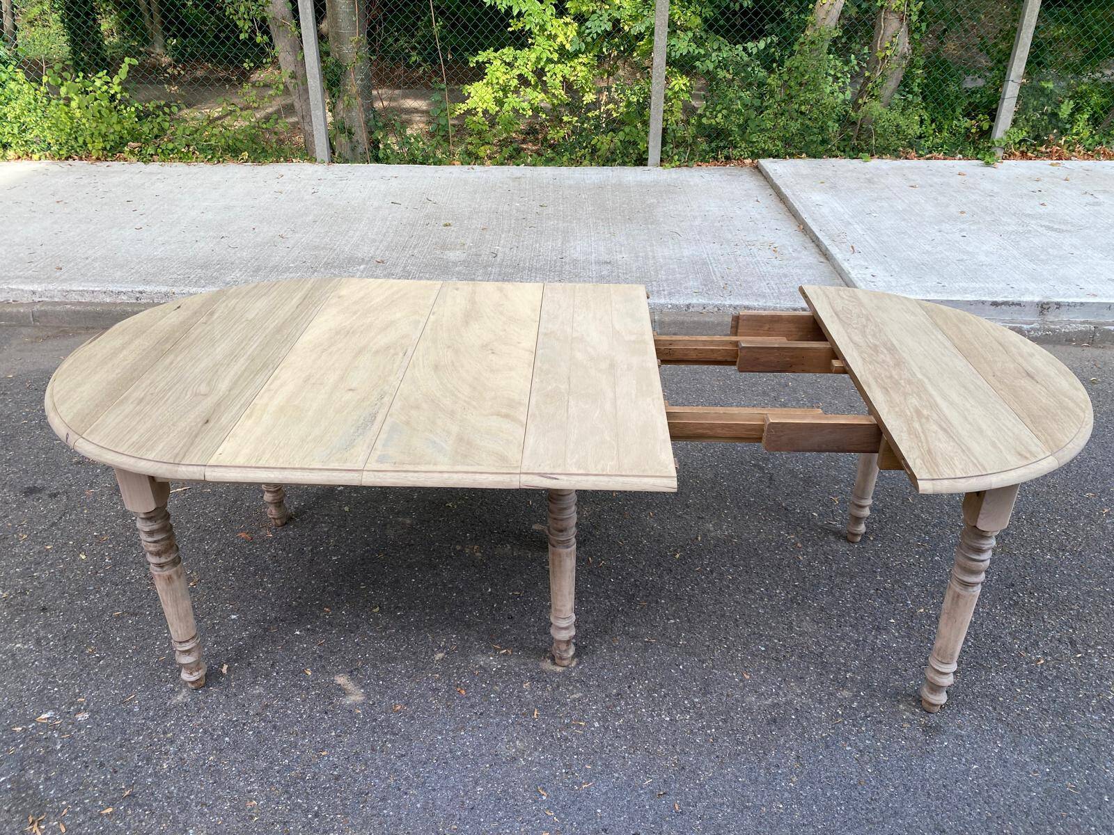 Round extendable dining table with flaps, stripped in raw oak, with 3 extensions.
