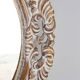 Distressed and carved golden oval mirror in wood.