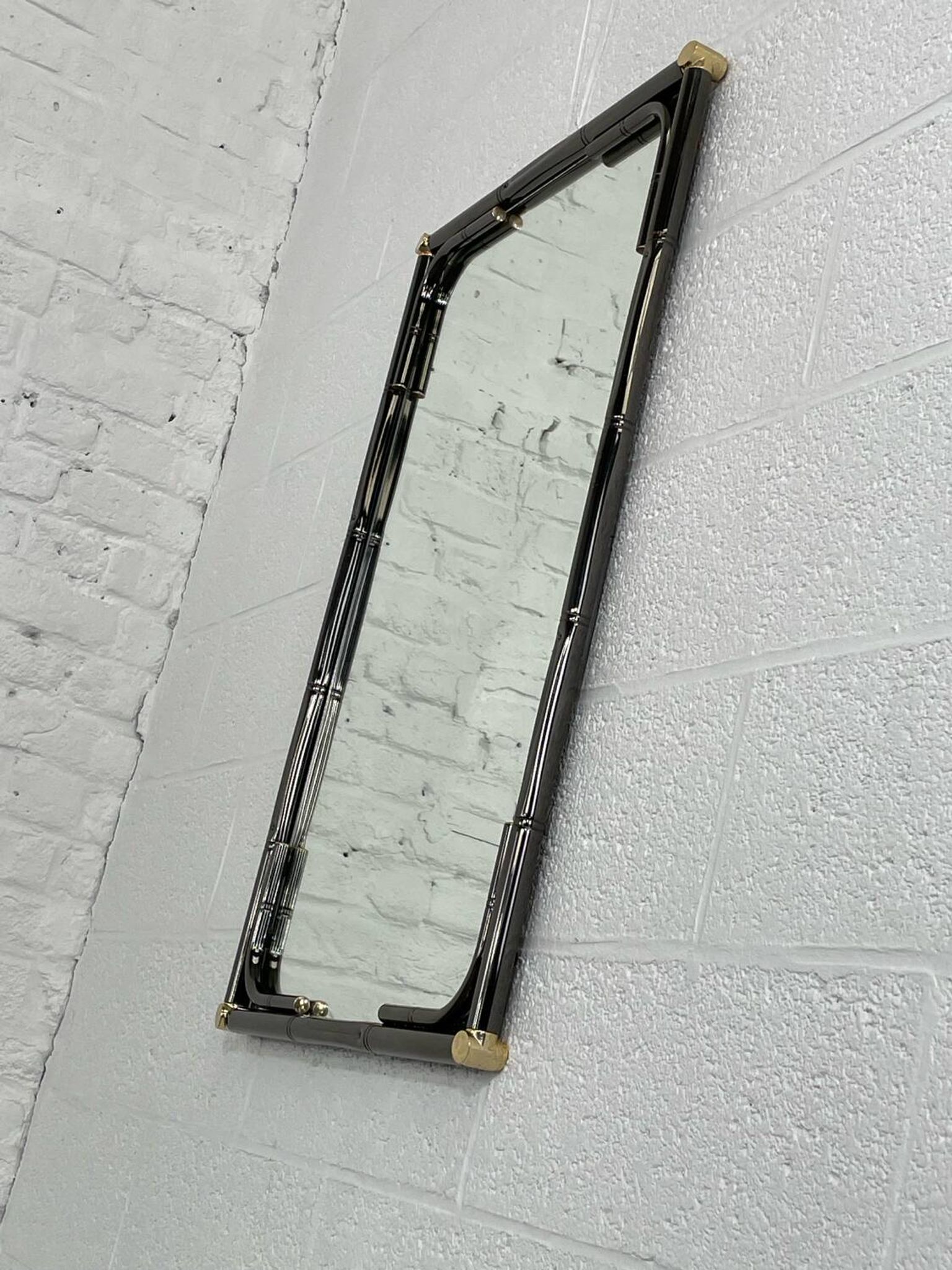 Mirror in black metal and brass with gunmetal finish