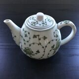 Green plant-decorated teapot