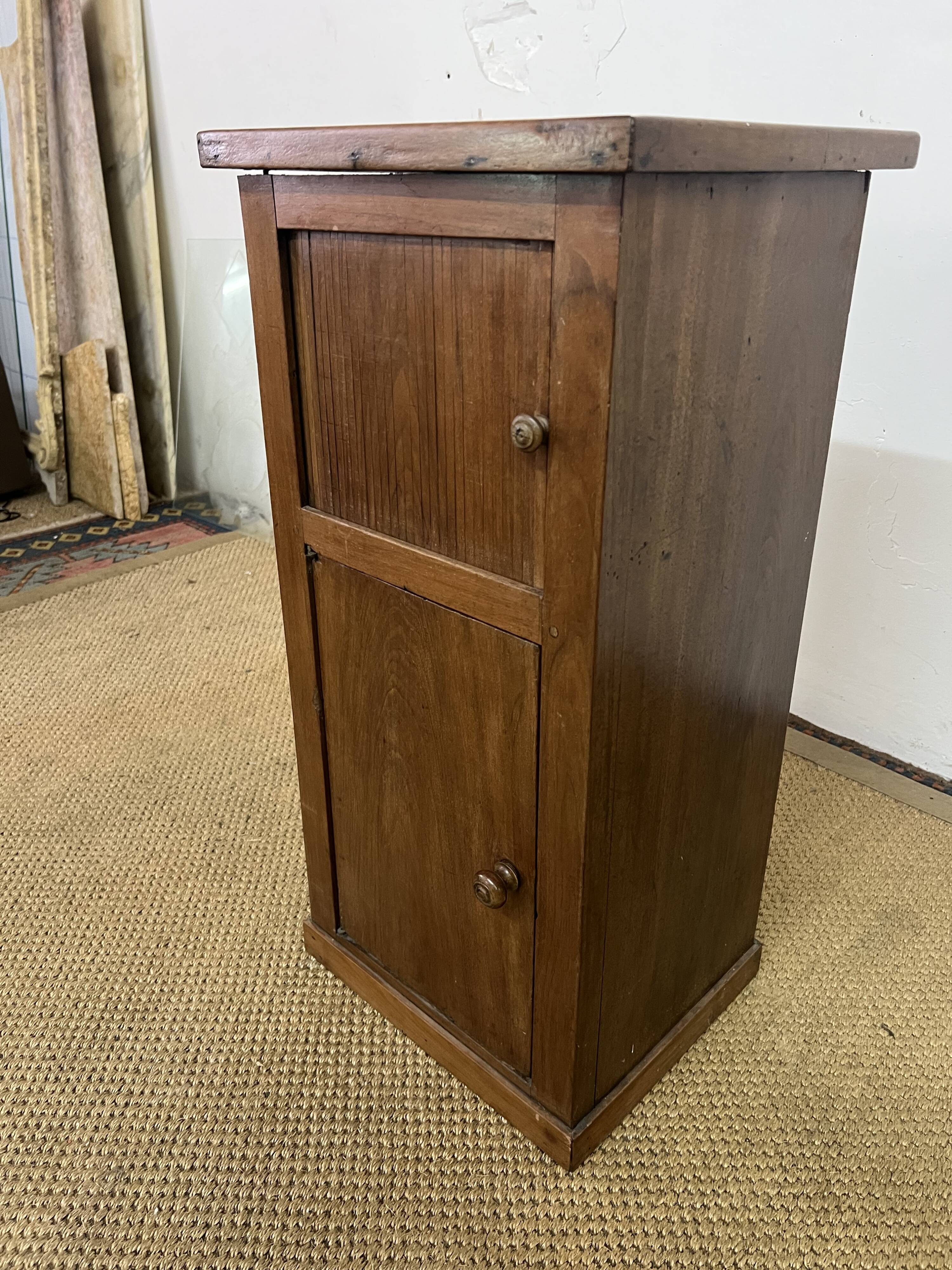 Old small storage unit with sliding and hinged doors.
