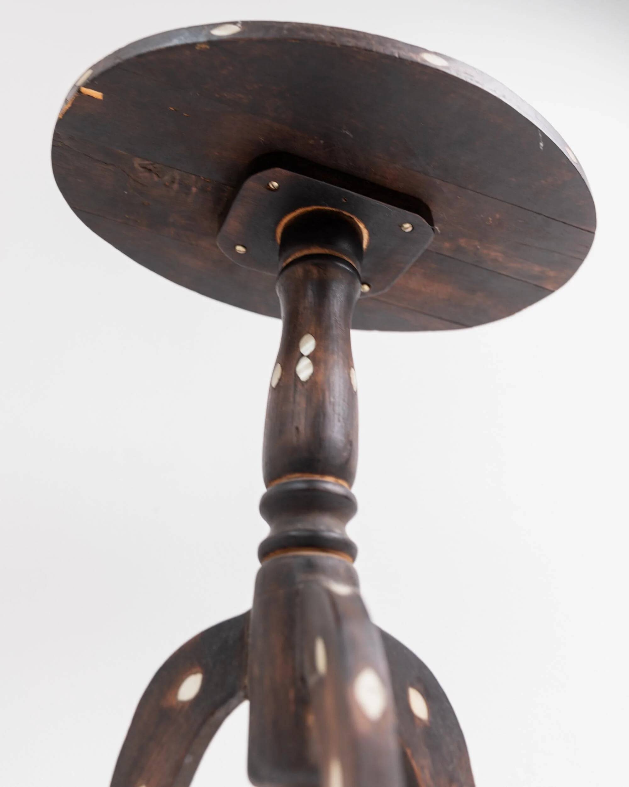Vintage side table from the early 19th century, dark wood with mother-of-pearl inlays, oval shape with three legs, ethnic style.
