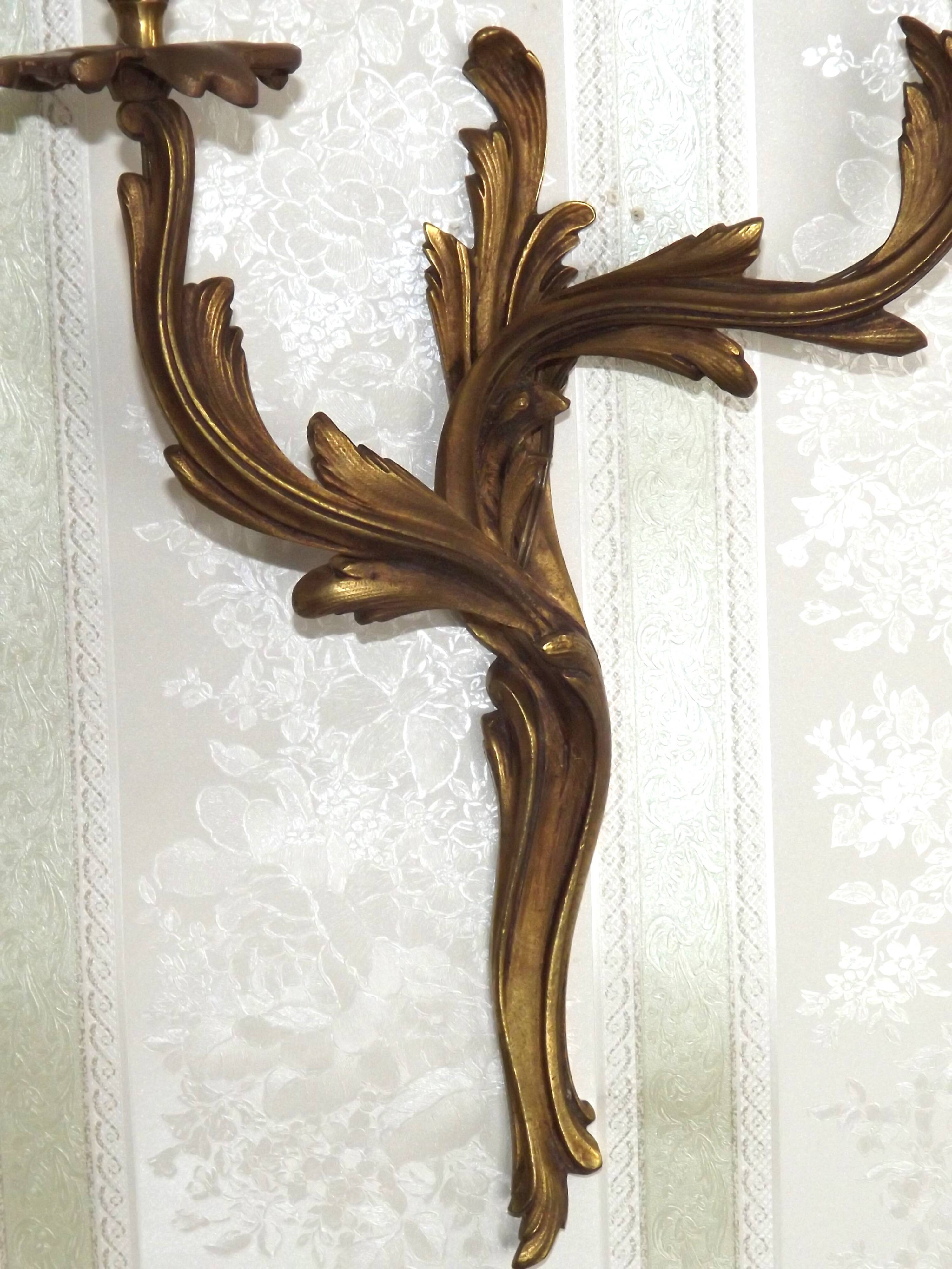 Apply two bronze wall lights decorated with acanthus leaves.
