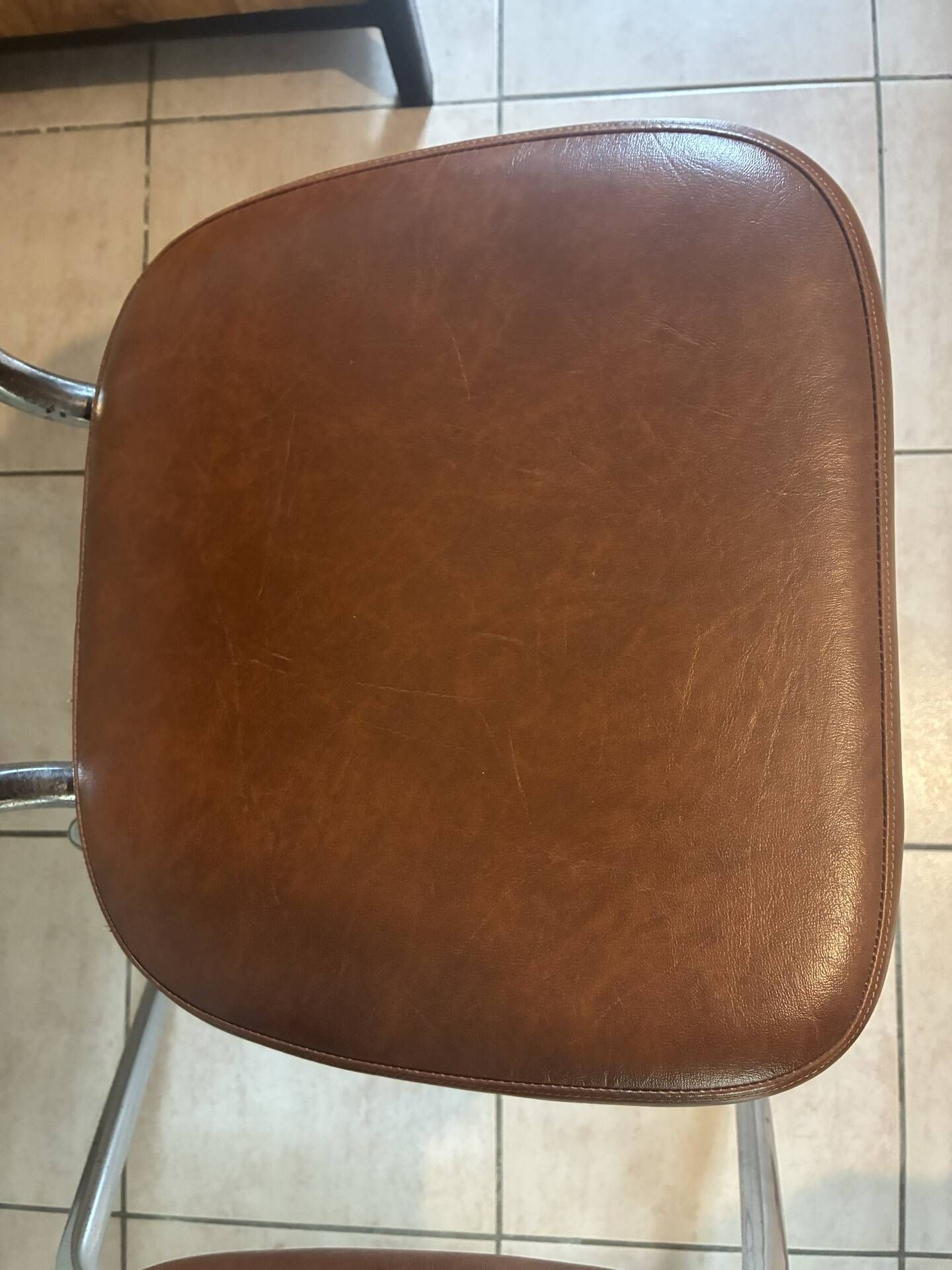 Two brown faux leather chairs.