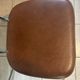 Two brown faux leather chairs.