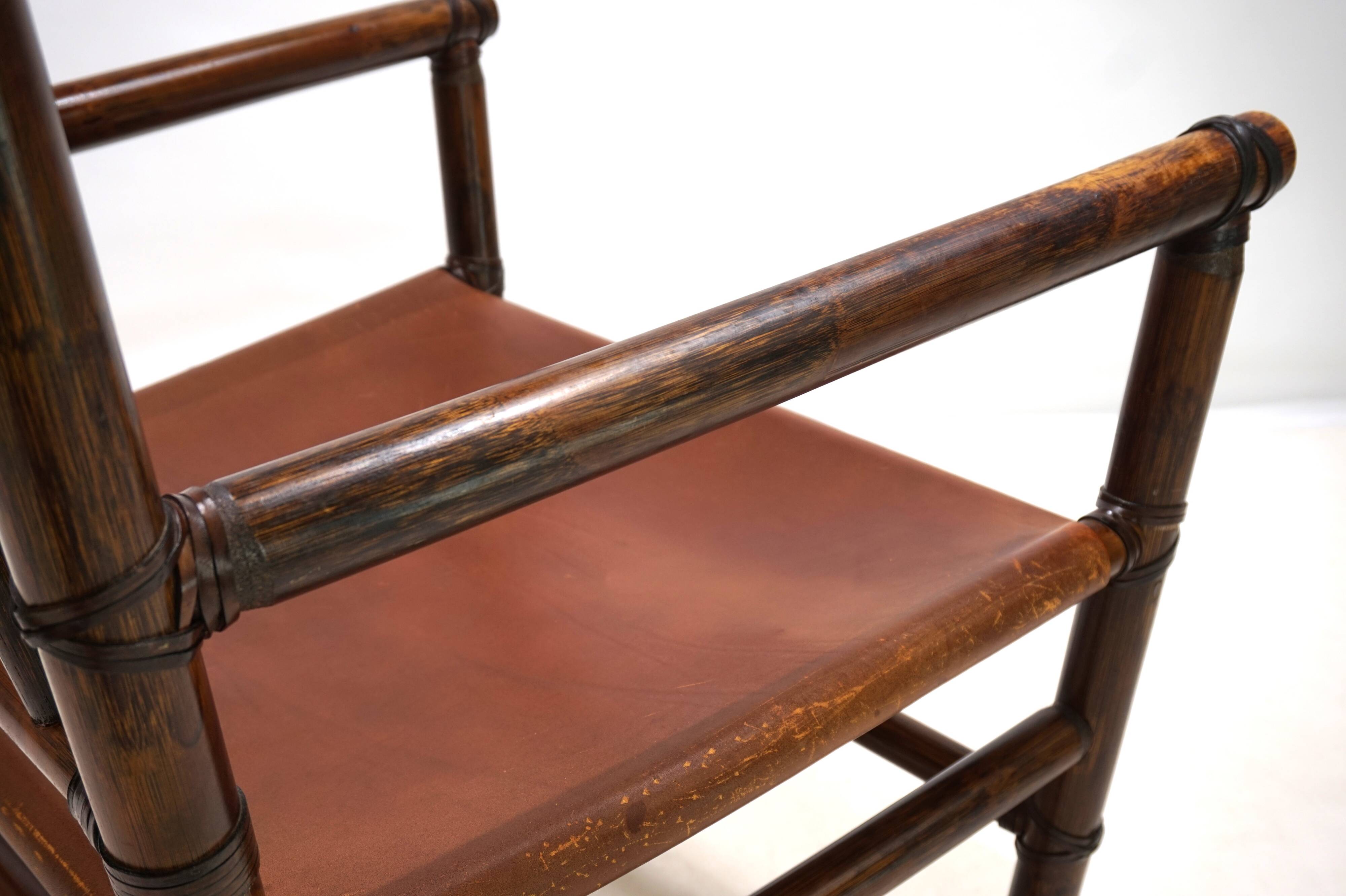 Fauteuil Manou en rotin et assise en cuir, 1960