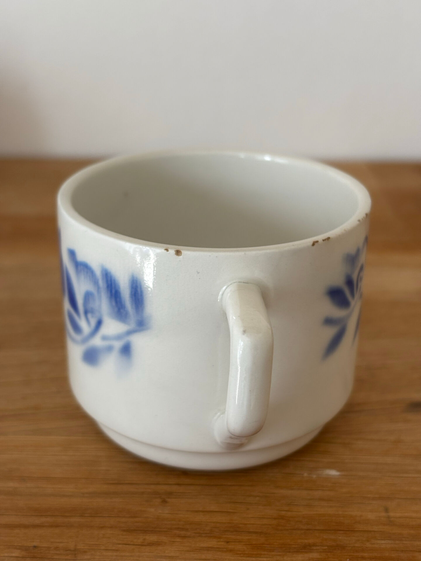 Set of 2 antique earthenware cups with blue floral pattern.