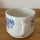 Set of 2 antique earthenware cups with blue floral pattern.