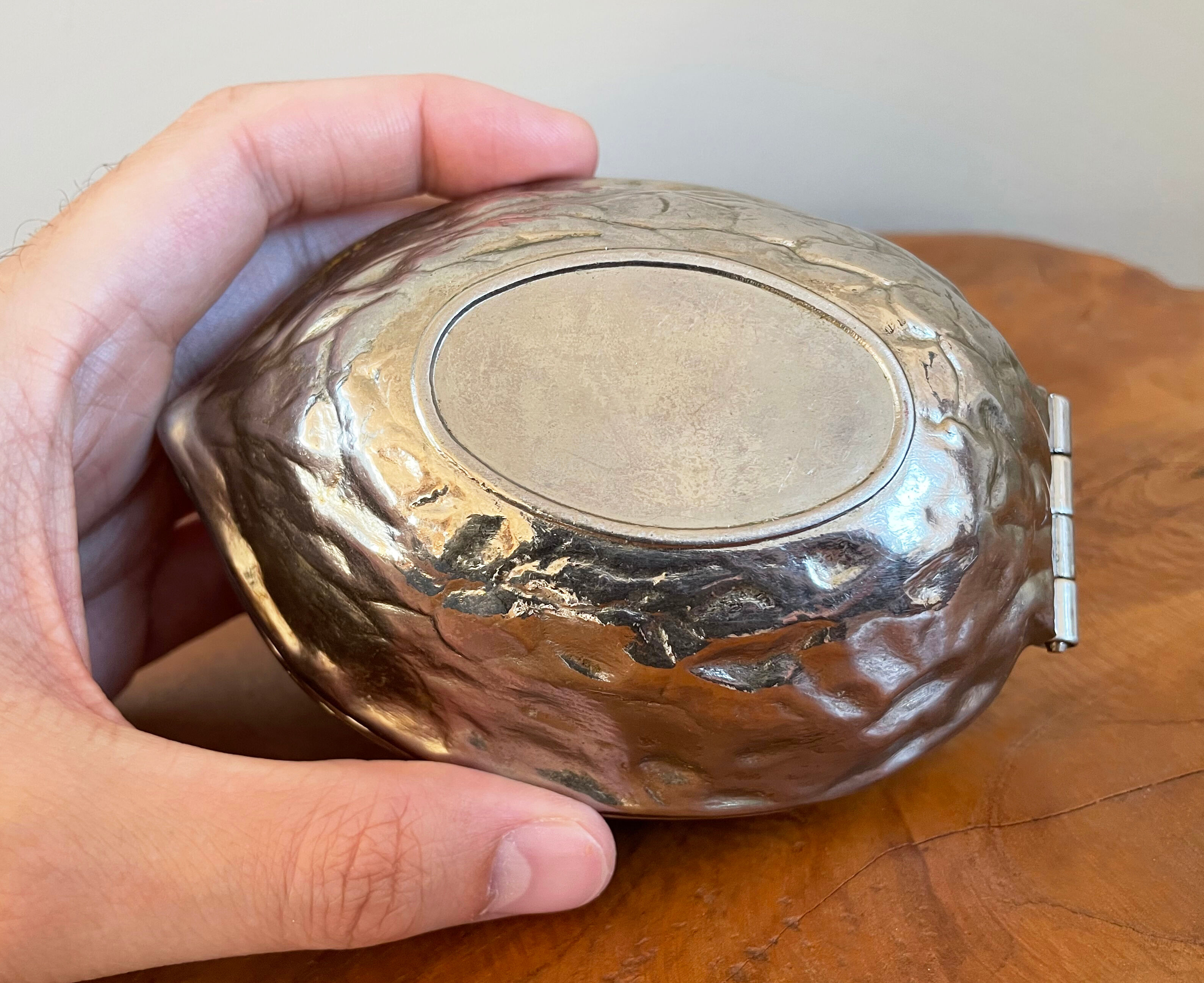 Silver metal nutcracker in the shape of a walnut