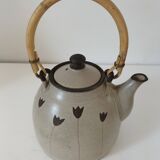 Beige stoneware teapot with stylized flowers and rattan handle