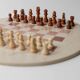 Vintage 1980s round chess set in marble, with a beige and pink marble board and wooden pieces.