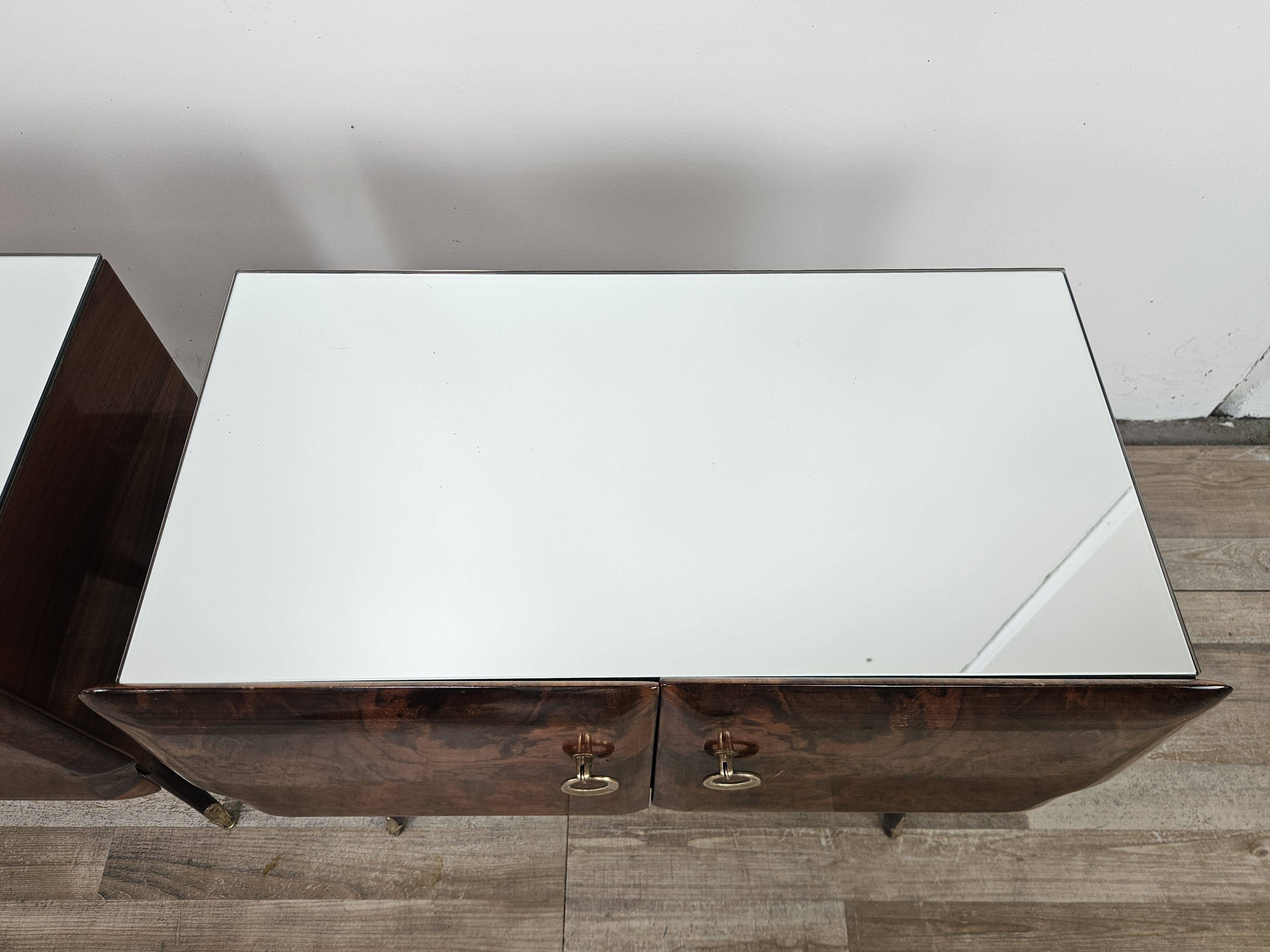 Mid-century mahogany bedside tables with mirrored tops.