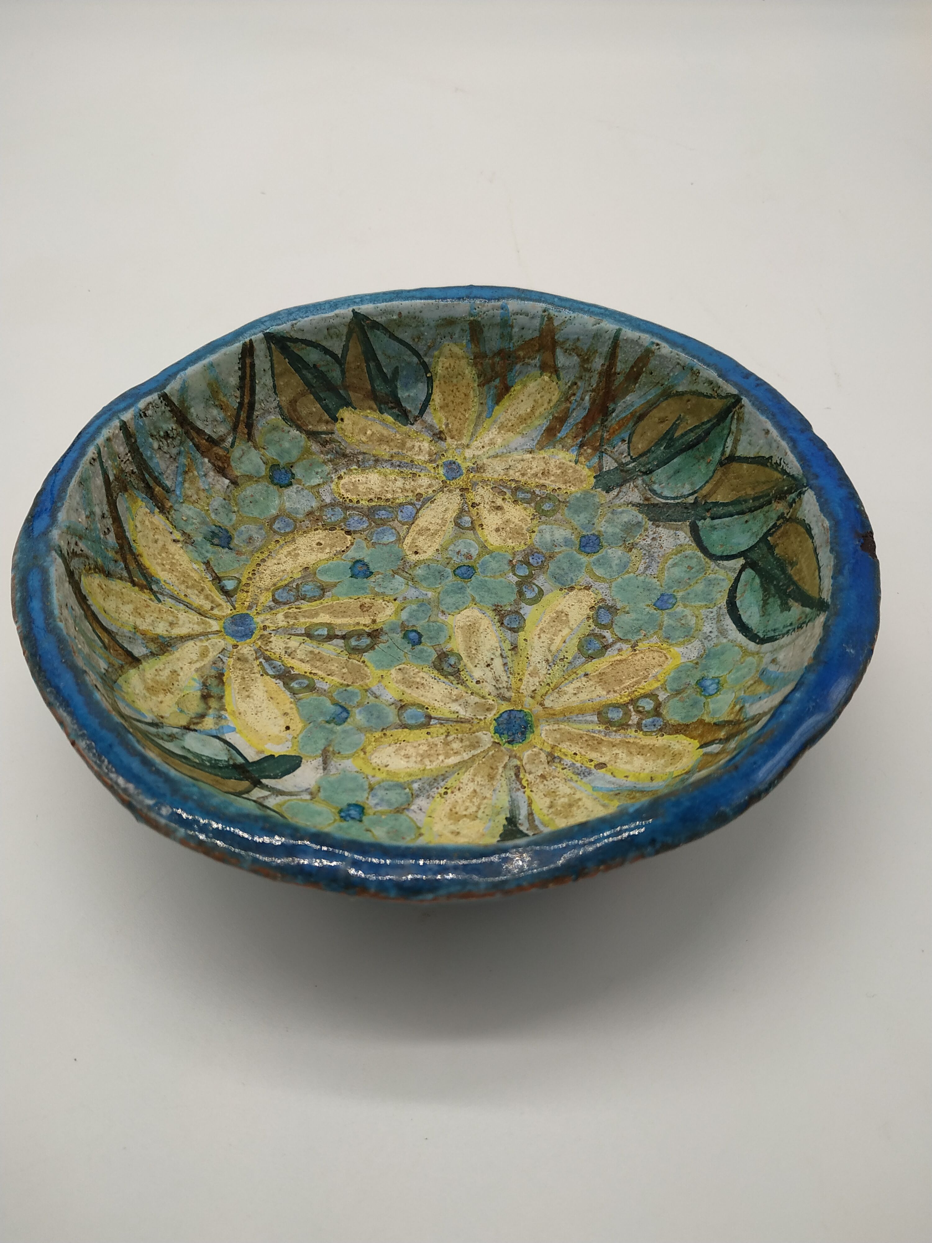 Hollow cut in blue enamelled sandstone decorated with yellow flowers