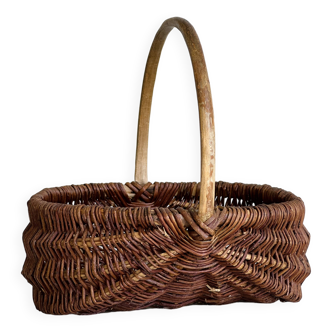 Woven wicker basket with a rounded wooden handle.