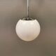 White hanging lamp with metal suspension, made with ball round opal glass shade.