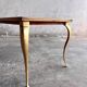 Table basse vintage avec pieds dorés et plateau incrusté de motifs géométriques en placage de bois brun clair