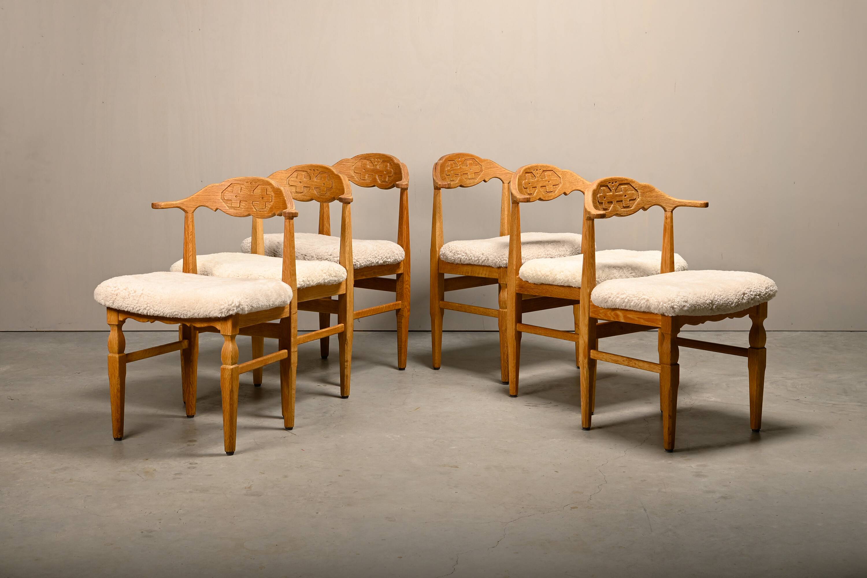 Henning Kjærnulf dining chairs set in Oak and Sheepskin, Denmark, 1960s