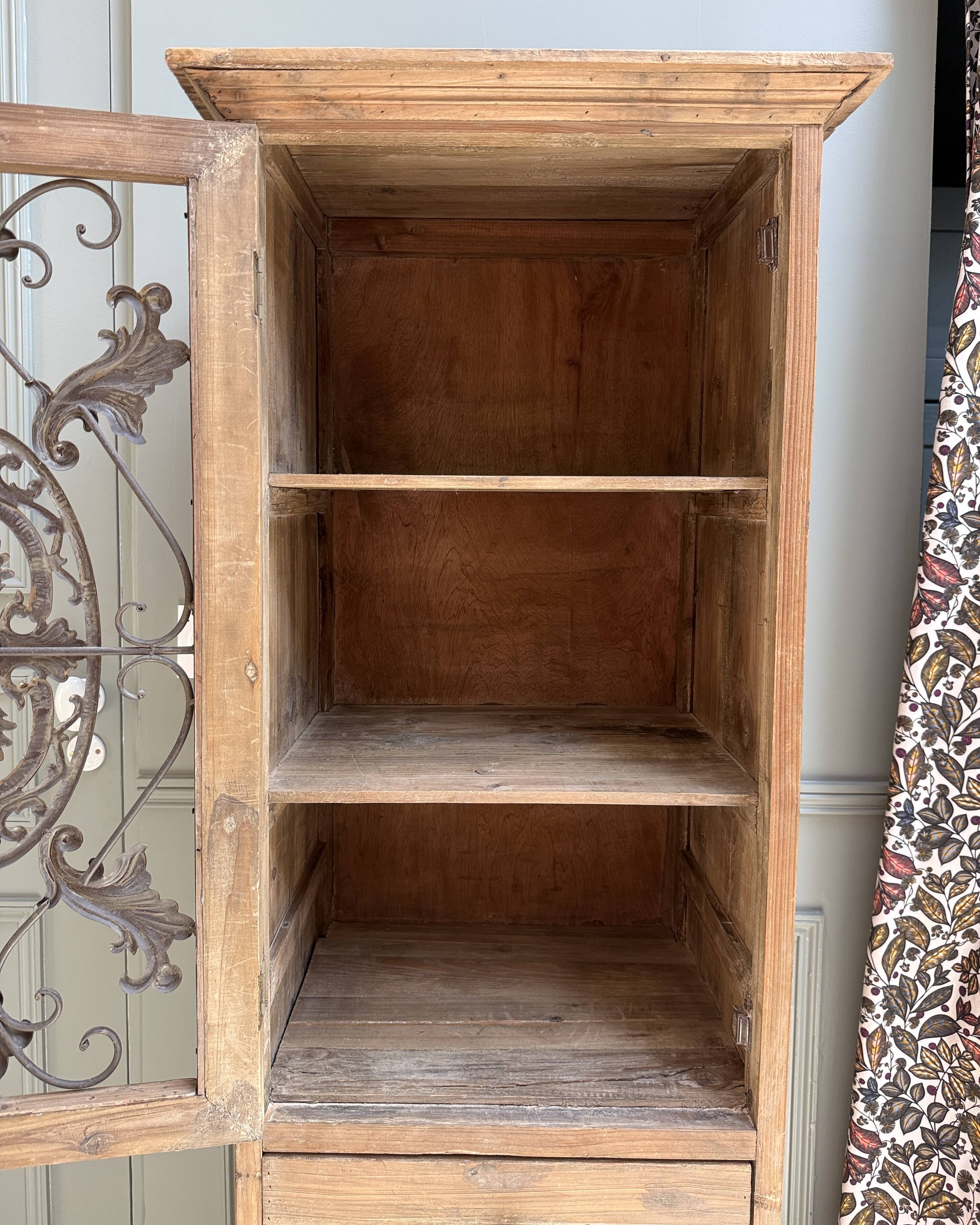 Column storage unit with a sculpted metal door.