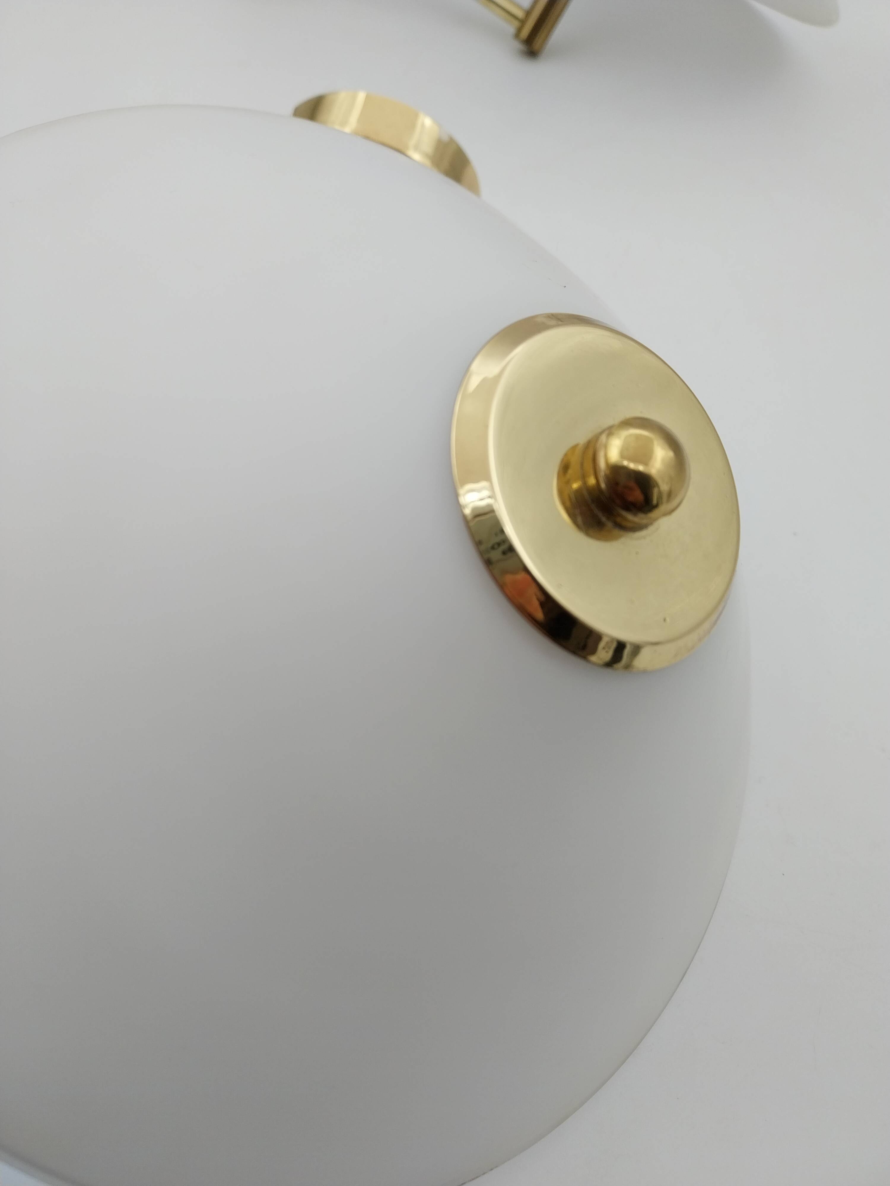 Pair of articulated arm wall lights in brass with opaline globe