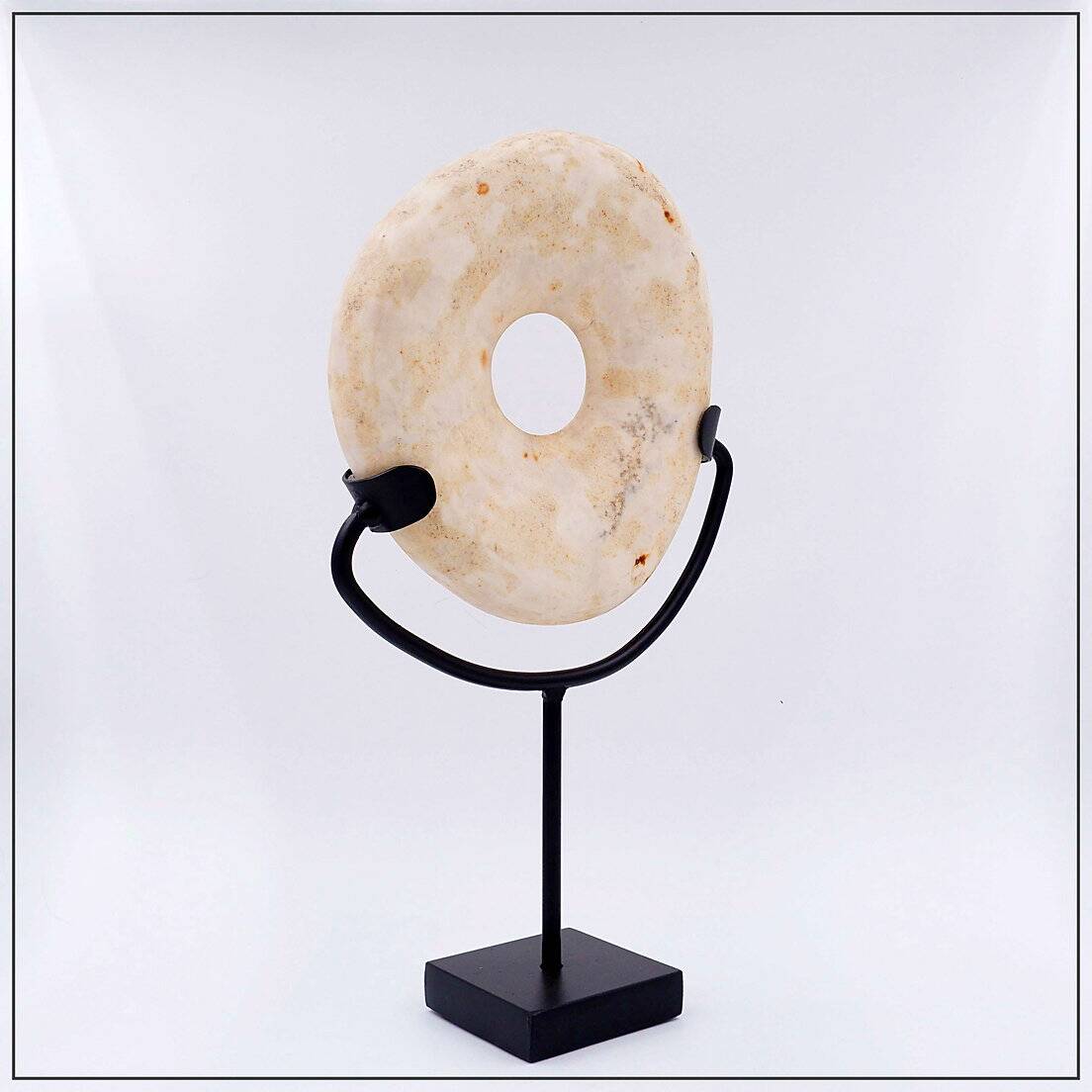 "Wamayuwa" Boiken coin in hand-carved shell mounted on a black metal stand
