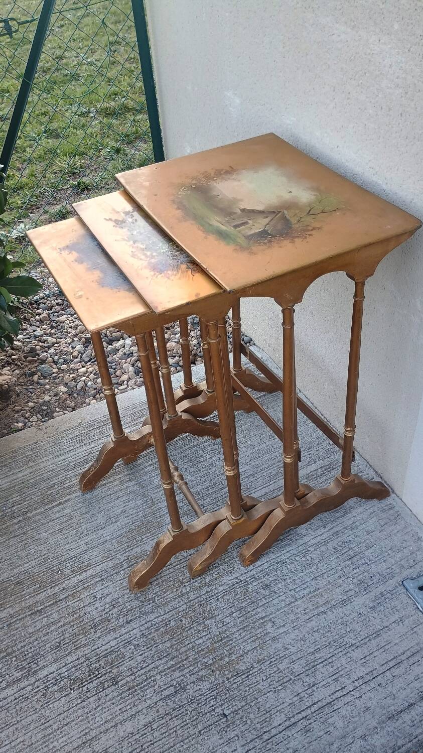 Sets of three nesting tables with painted landscape decorations in poplar.