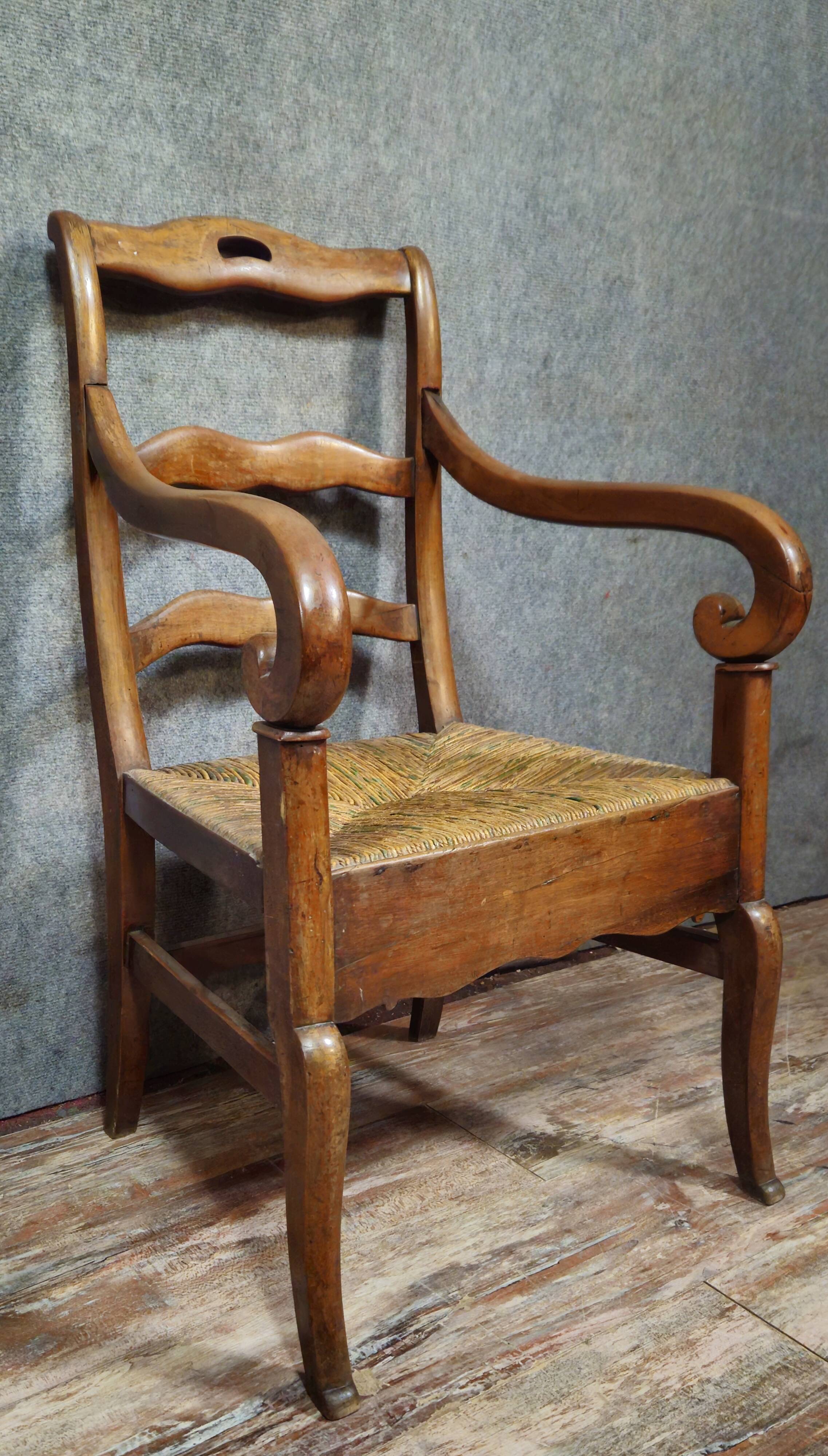 Empire armchair in solid walnut with woven straw seat.