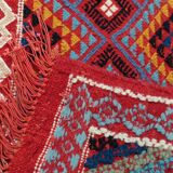 Red carpet with multicolored Berber patterns woven with hands