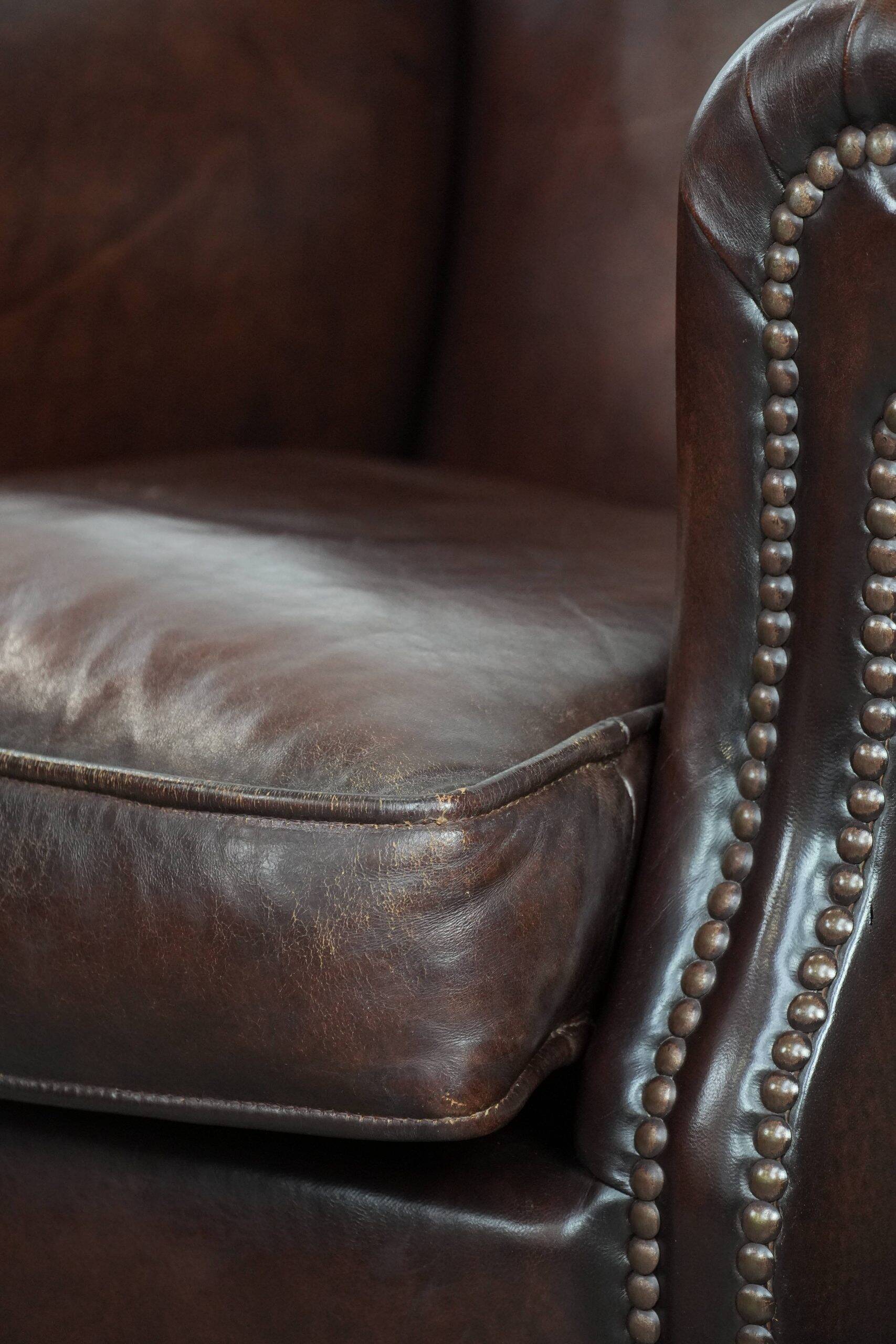 Sheepskin armchair with a classic finish and decorative studs.