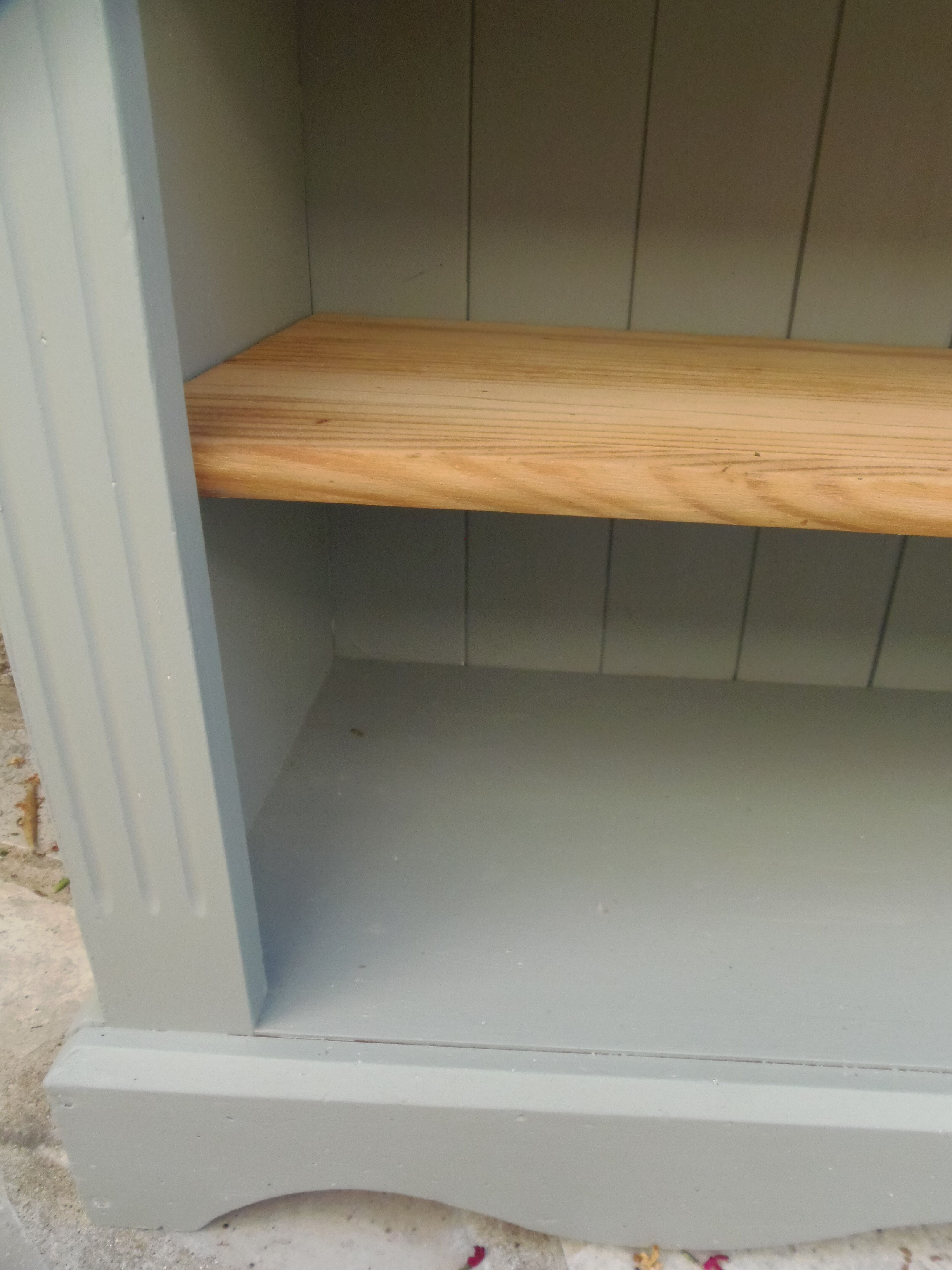 Green-grey library, wooden shelf and shelves in natural wood.