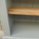 Green-grey library, wooden shelf and shelves in natural wood.