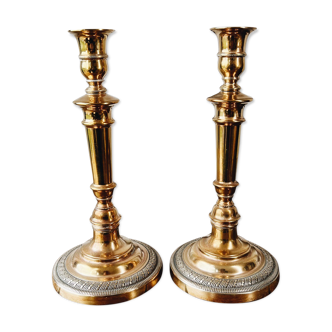 Duo of brass candle holders, chiseled feet