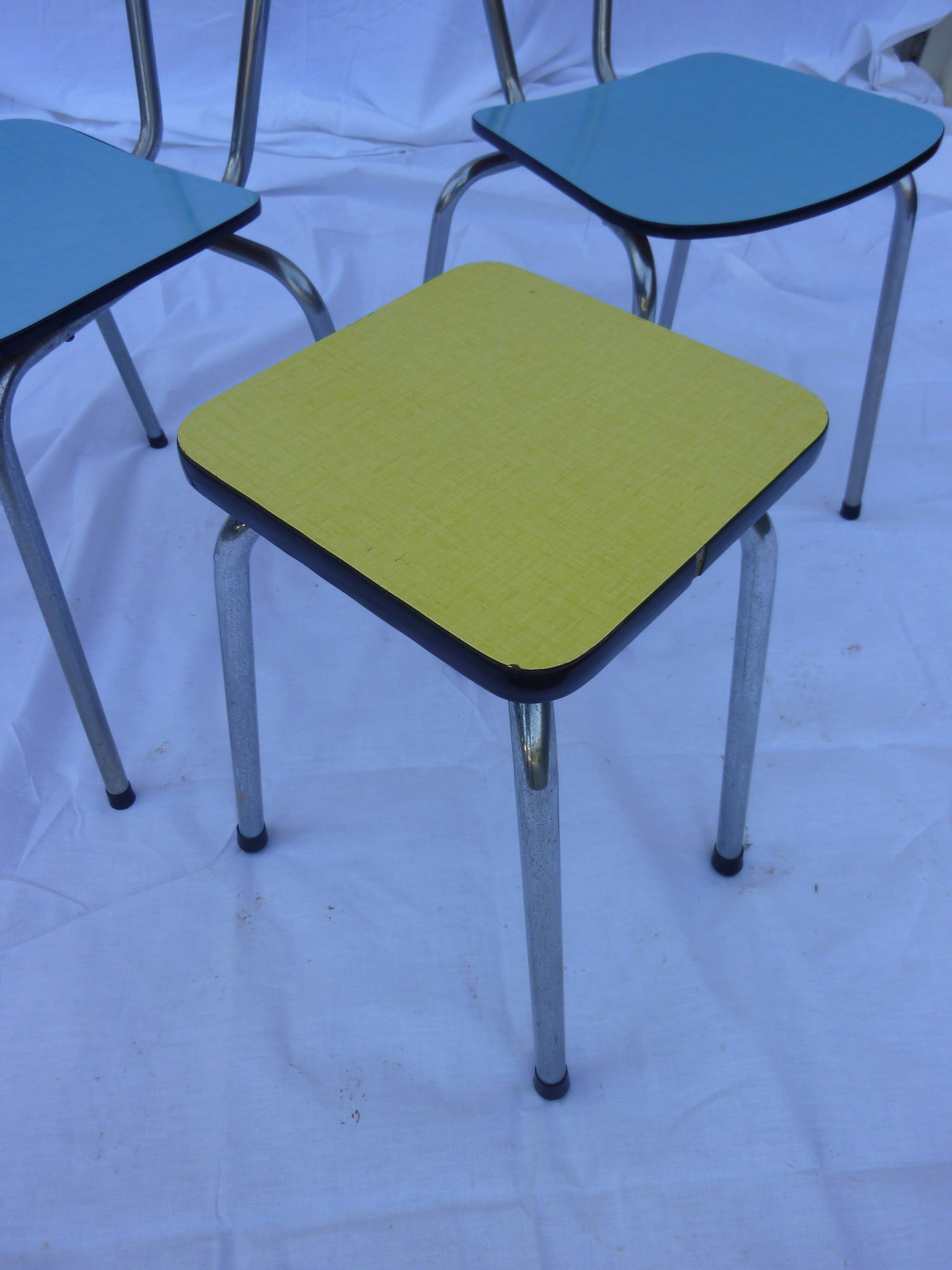 Two chairs and a yellow and blue stool in formica