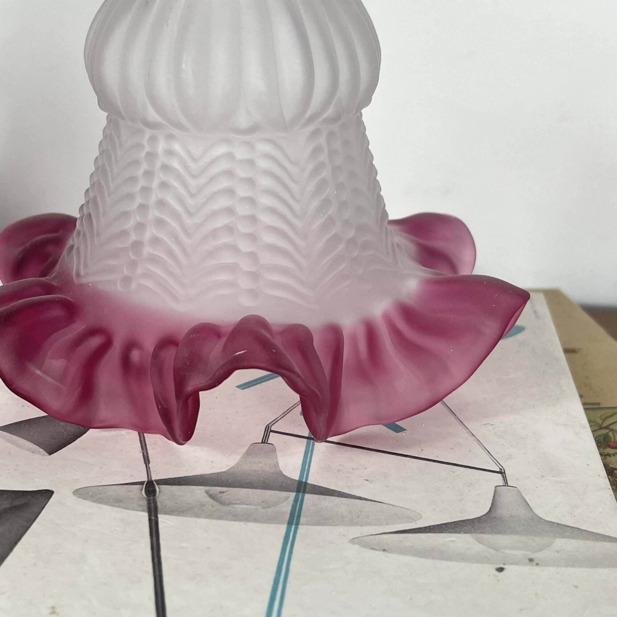 Antique tulip lampshade in transparent glass with a red rim.