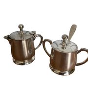 Two small silver-plated metal tea service pots from the 20th century.