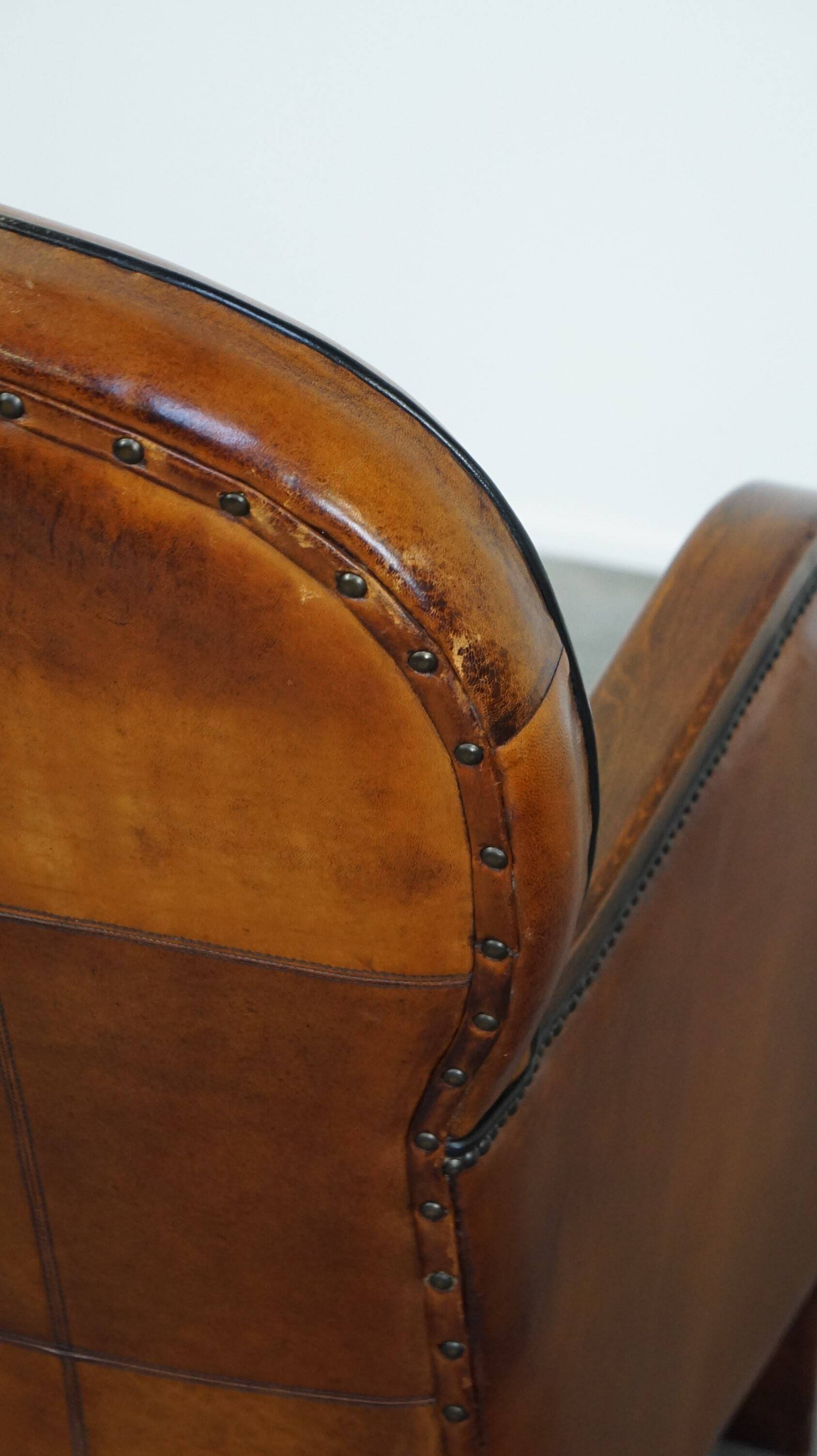 Unique, luxurious sheepskin armchair combined with wood and finished with decorative nails