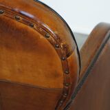 Unique, luxurious sheepskin armchair combined with wood and finished with decorative nails