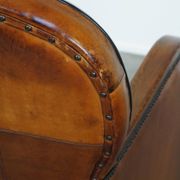 Unique, luxurious sheepskin armchair combined with wood and finished with decorative nails
