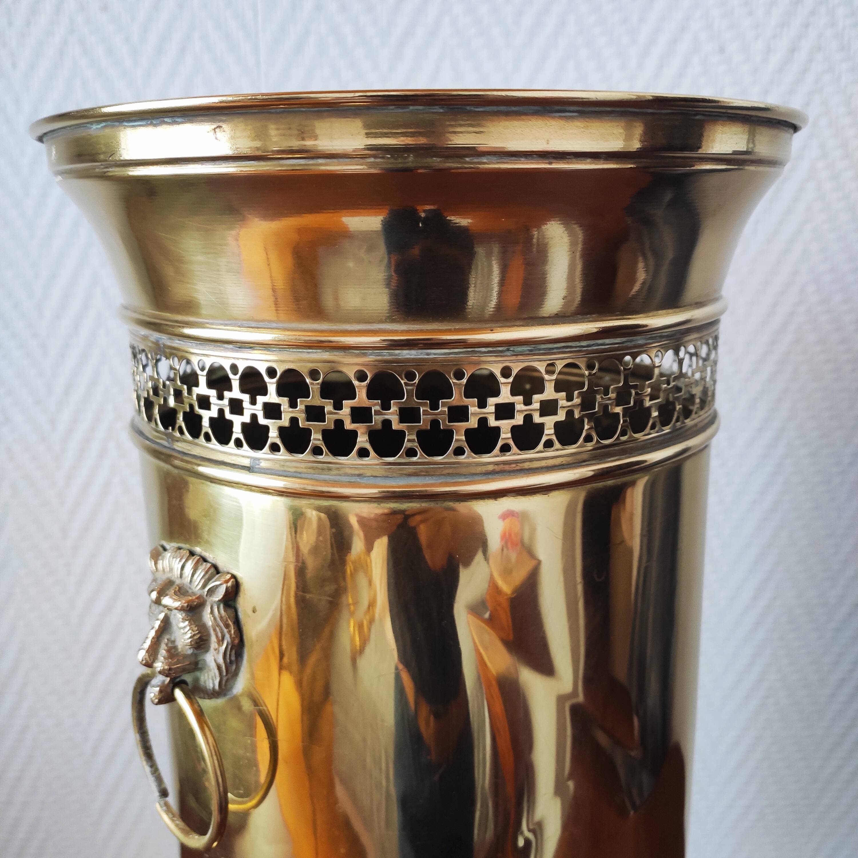 Vintage brass umbrella stand with lion decoration.