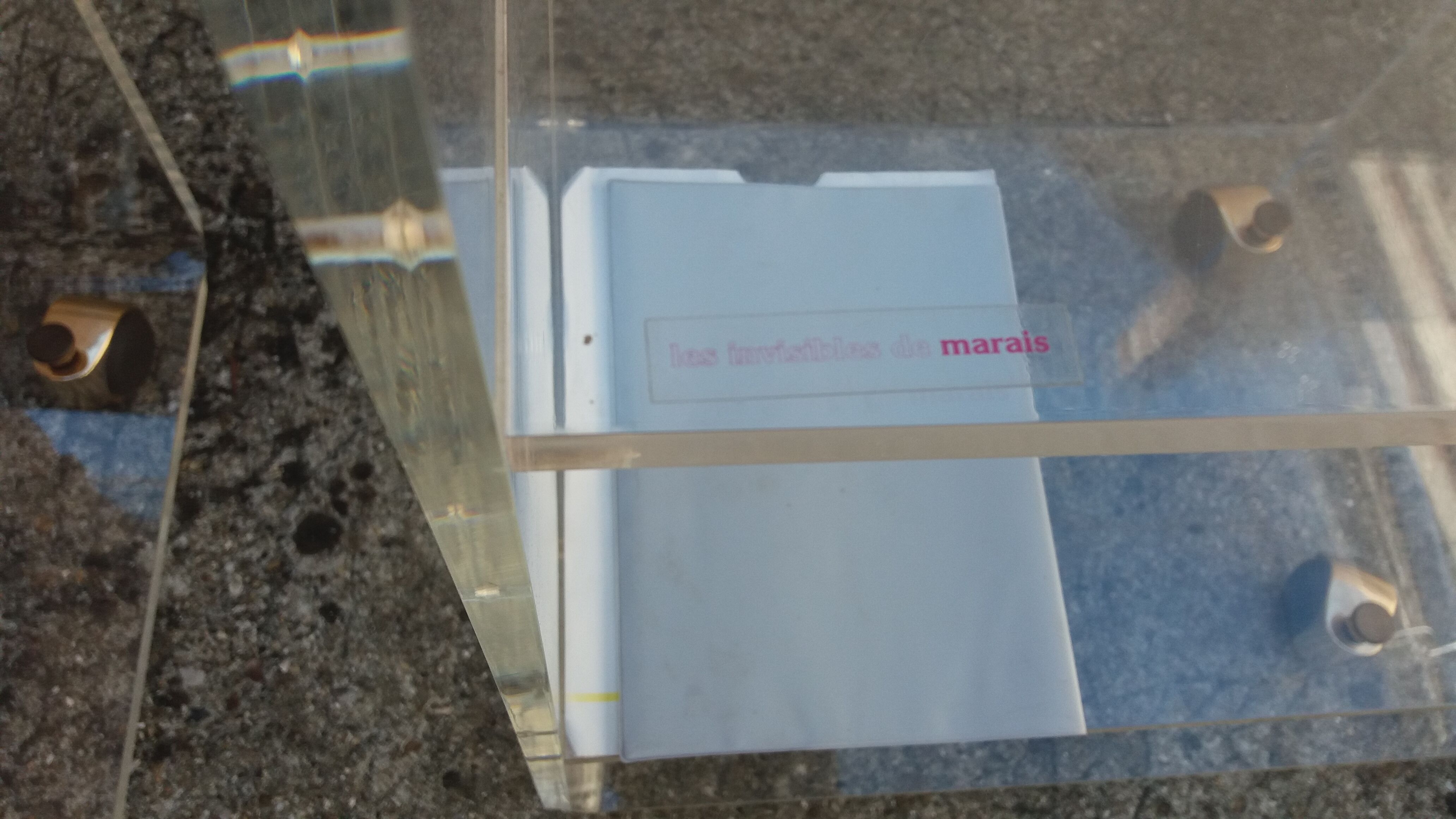 Pair of Plexiglas services branded "Les Invisibles du Marais"