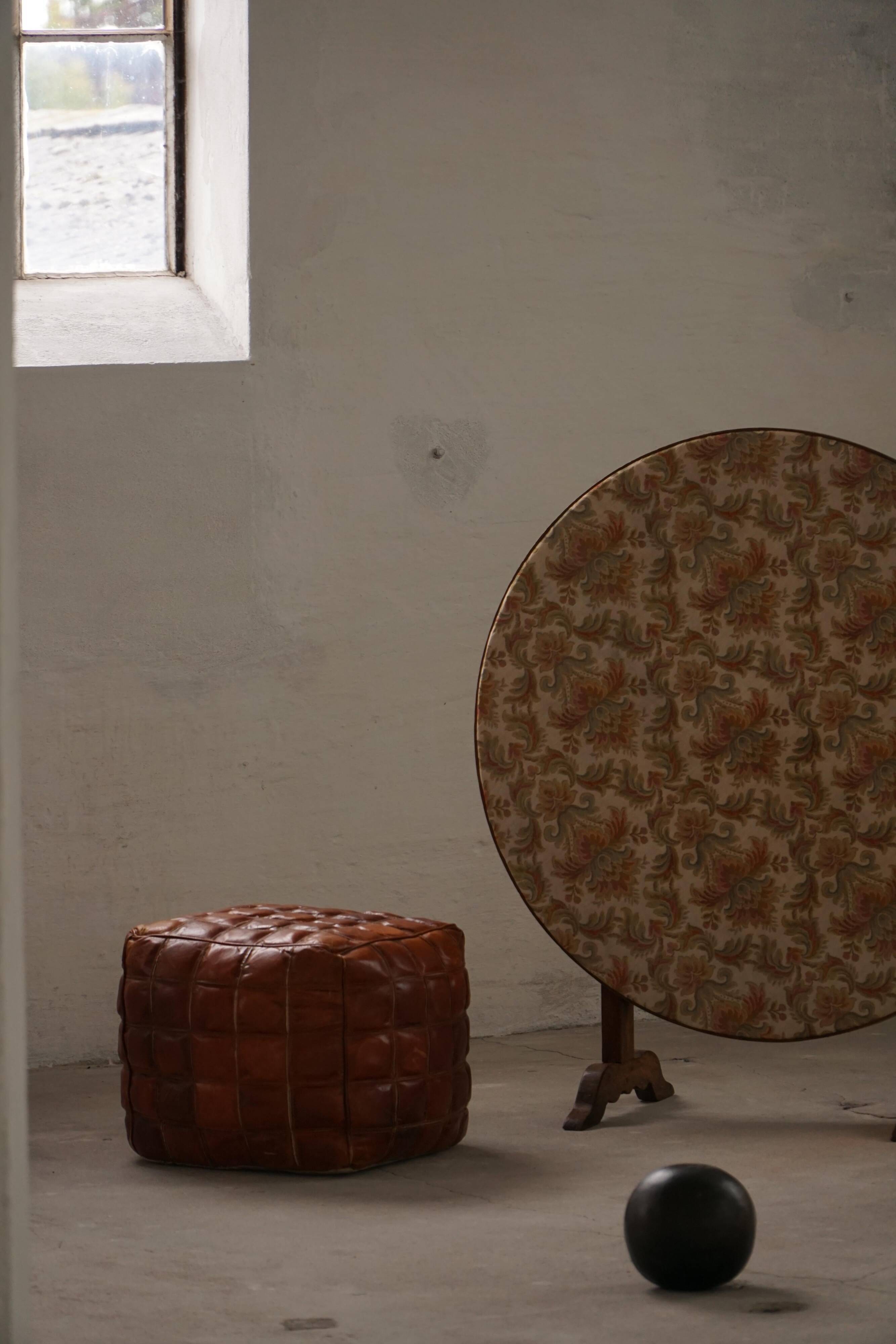 19th-century French round wine table with an adjustable top and floral textile surface.