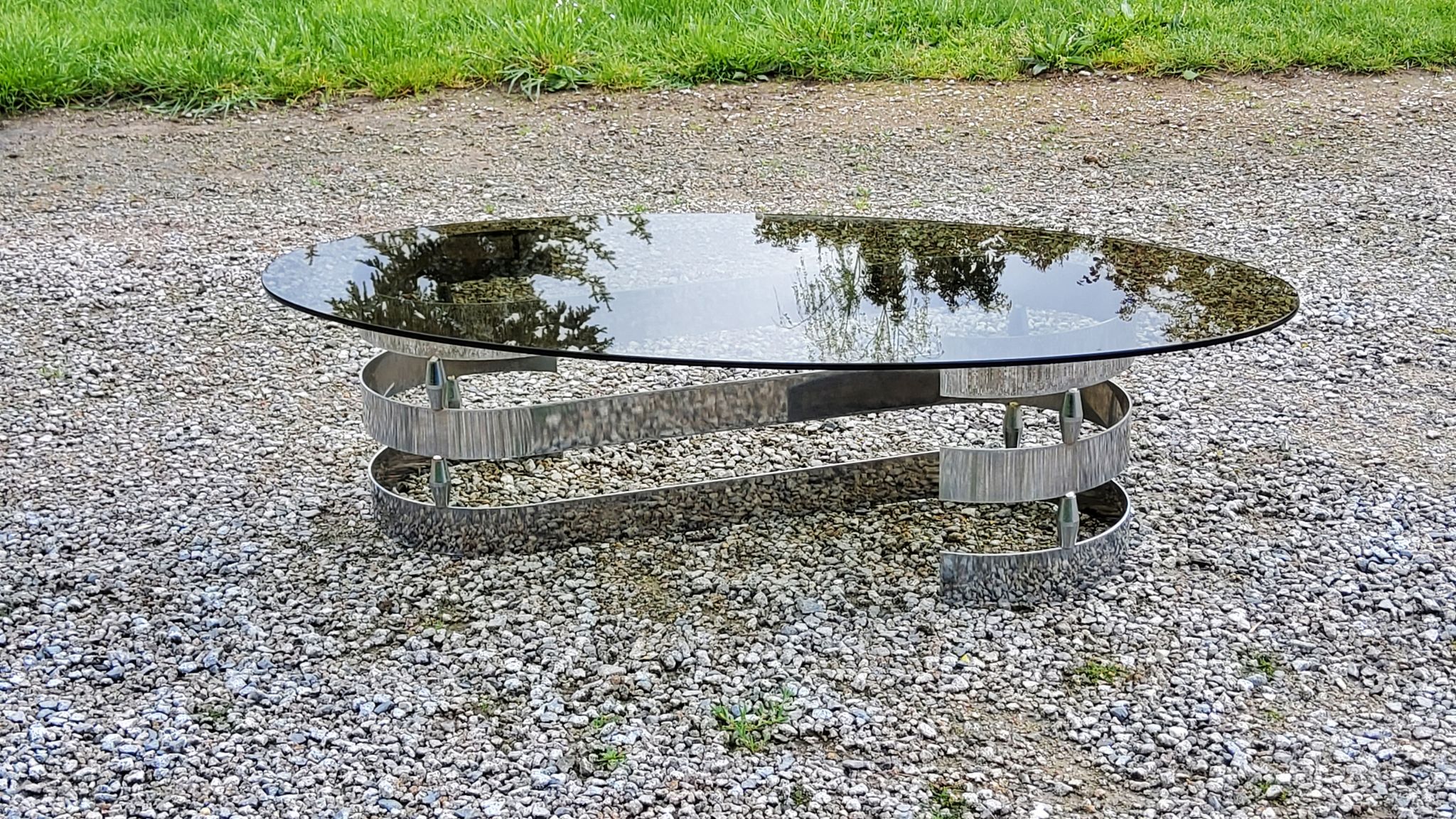 Oval coffee table of the 70s chromed metal base in s smoked glass top