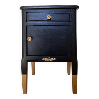 Old bedside table with marble and black and gold colored inserts