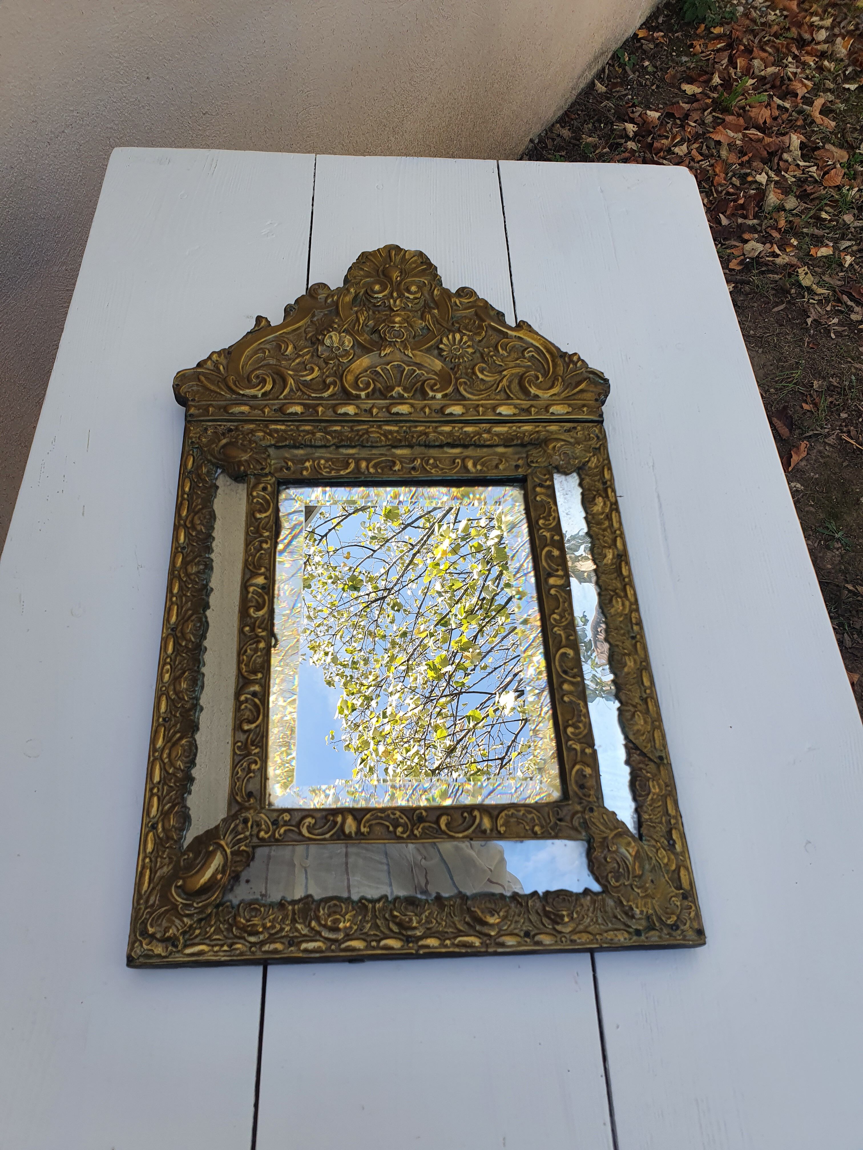 Miroir à parecloses en bois doré et métal repoussé