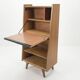 Vintage 1960s secretary desk with an angled design, light wood, and tapered legs.