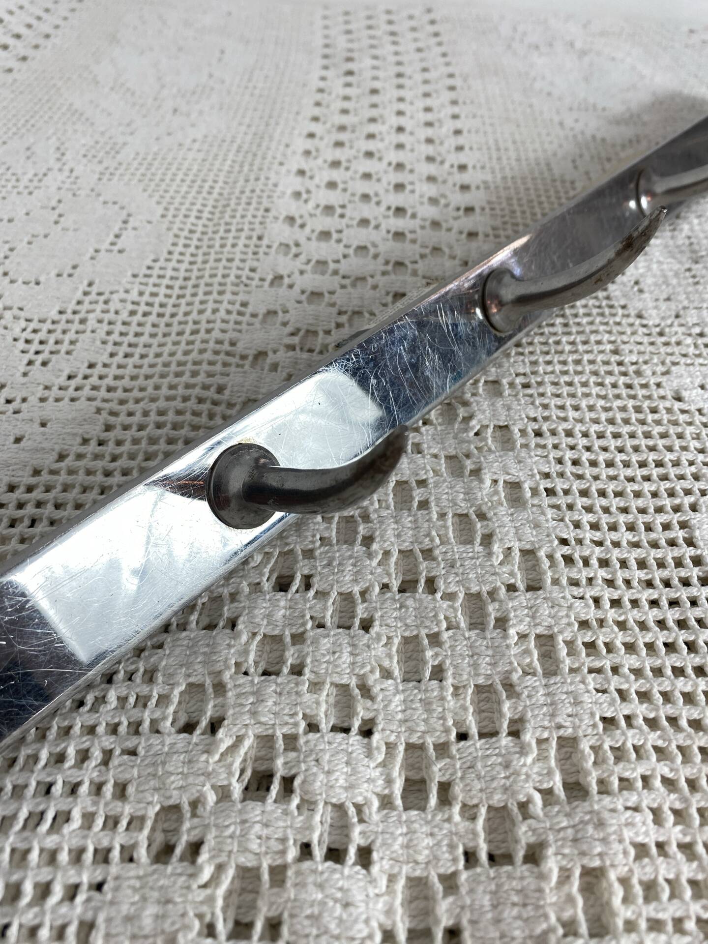 Stainless steel butcher's hook, known as a "wolf tooth bar."