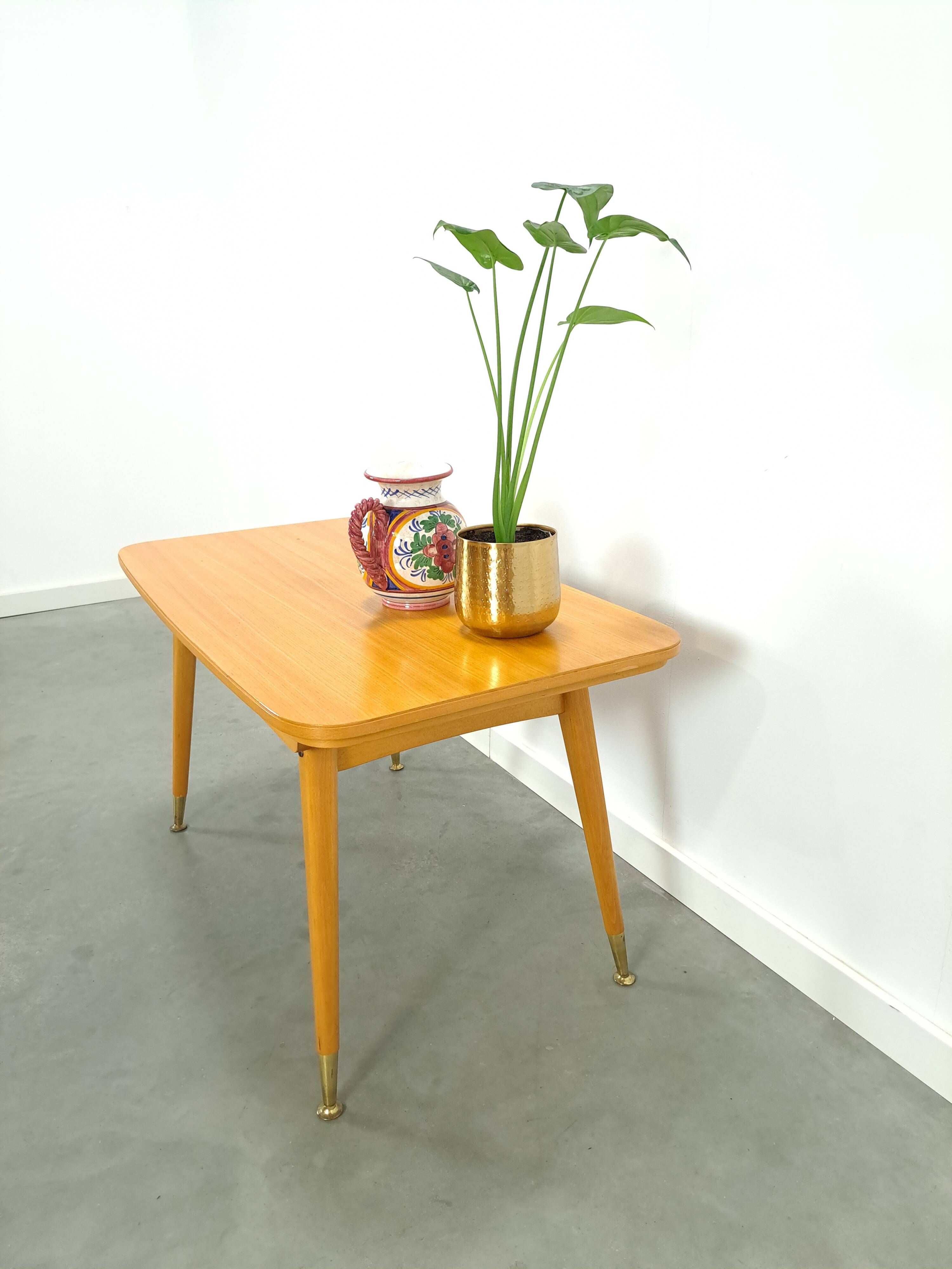 Vintage veneer table with pretty angular legs and brass at the base of the legs.