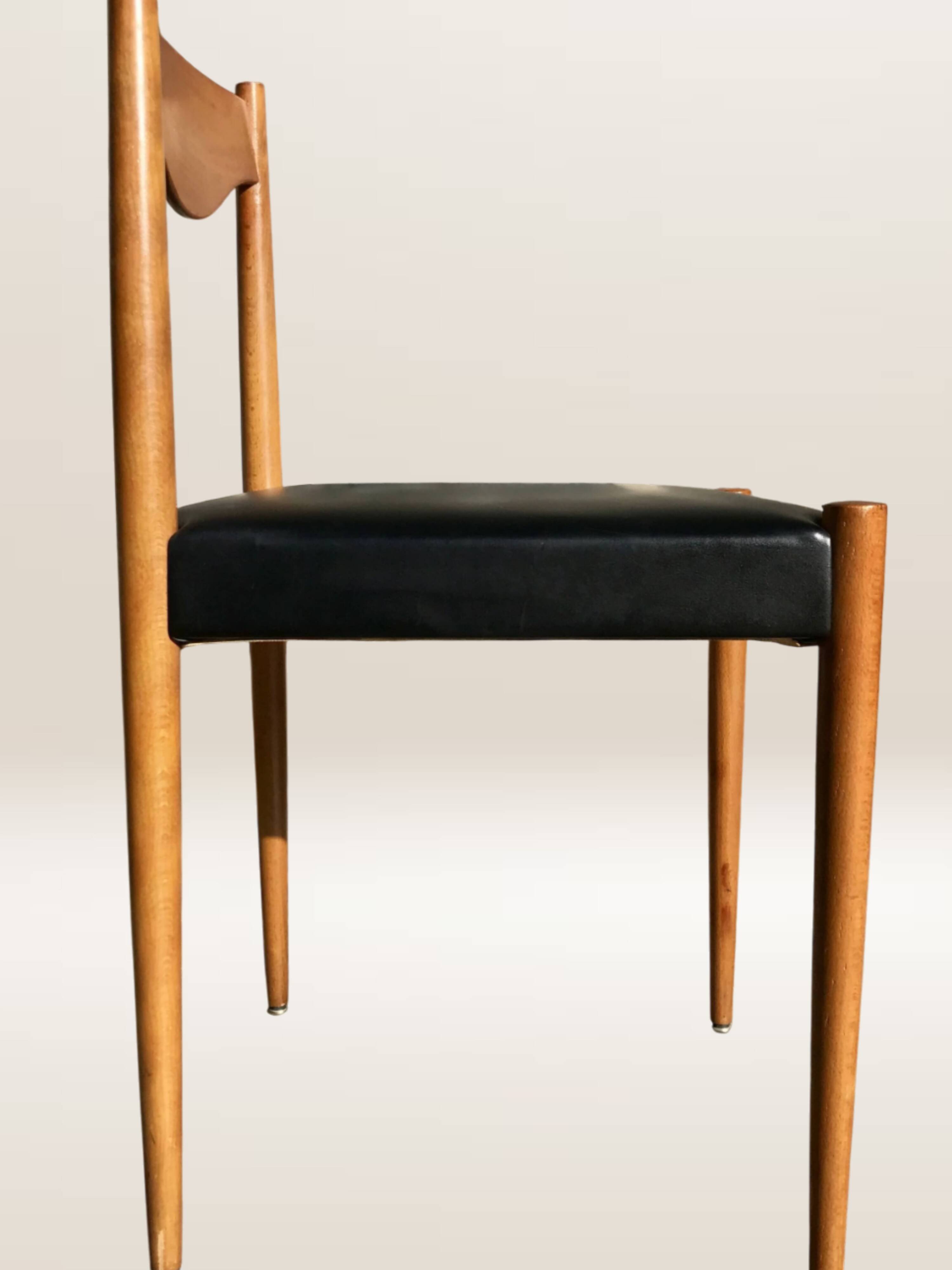 Set of 6 modernist chairs with black faux leather seats.