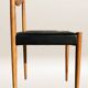 Set of 6 modernist chairs with black faux leather seats.