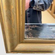 Large antique French gilded mirror with painted floral decoration.