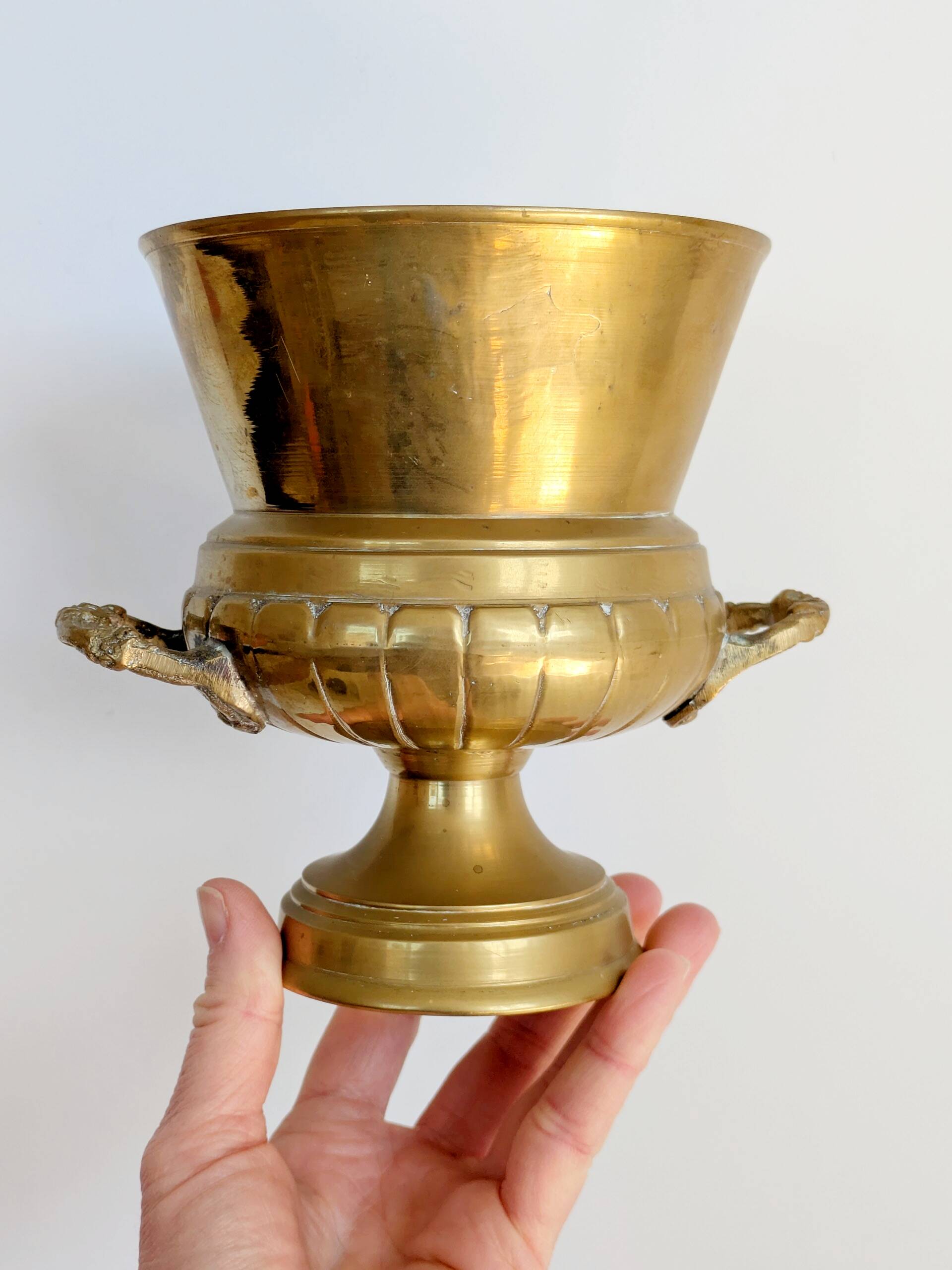 Vintage brass cache-pot on a stand with handles, classic decor.